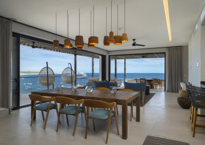dining room facing 2 walls of windows and expansive ocean view