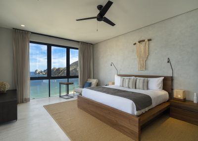 Bedroom facing wall of windows and ocean view